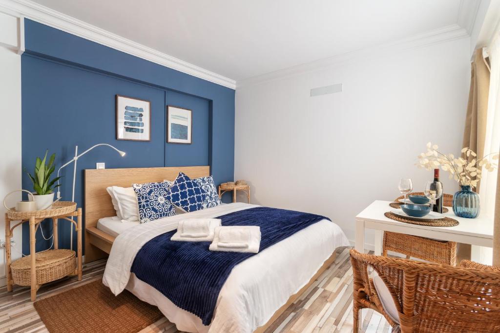 a bedroom with a blue accent wall and a bed at Praia da Rocha Beach Bright Apartment 50 m walk from the ocean in Portimão
