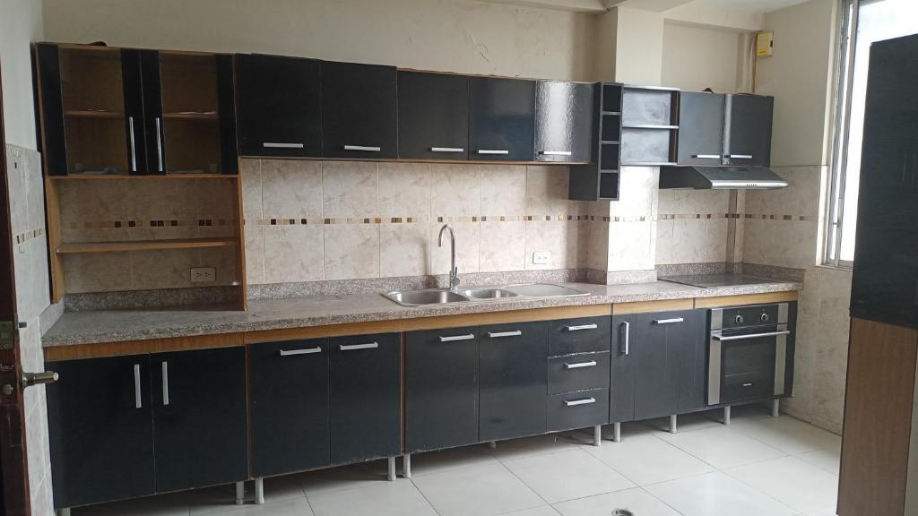 a kitchen with dark blue cabinets and a sink at Barlovento1 in Esmeraldas
