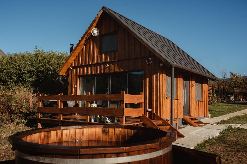 Cabaña de madera con una gran bañera de madera frente a ella en Beneháti kunyhók, en Mátrafüred