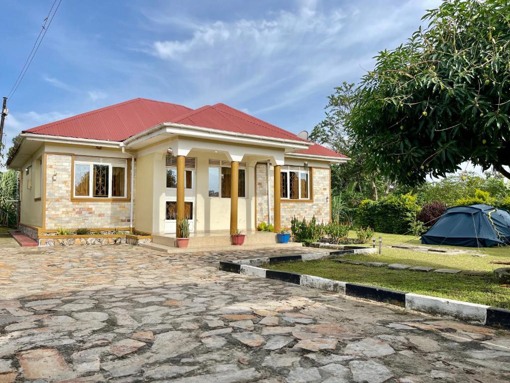 a small house with a red roof at Lake District Homestay in Rubirizi