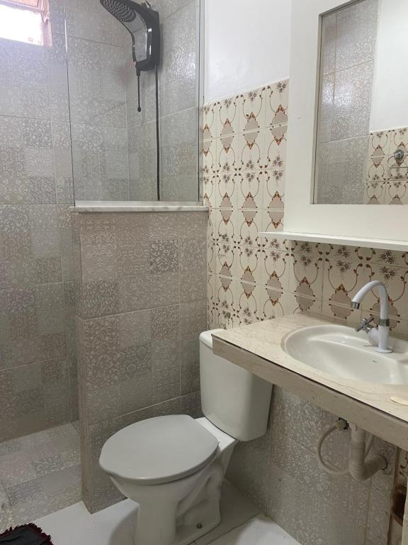 uma casa de banho com um WC, um lavatório e um espelho. em Hostel Carol em Boa Vista