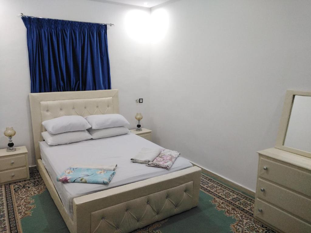 a bedroom with a bed with two pillows and a mirror at Your House For Family in Agadir