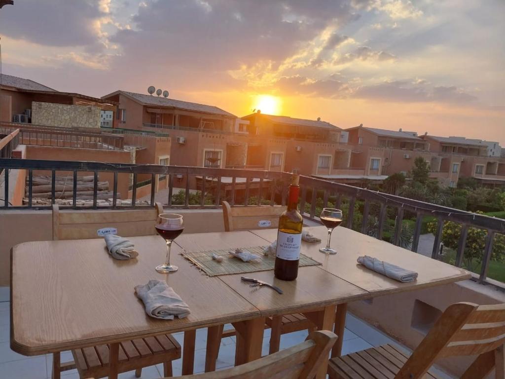 a table with two glasses of wine on a balcony at jenylyn`s chalet` families only` in Ain Sokhna