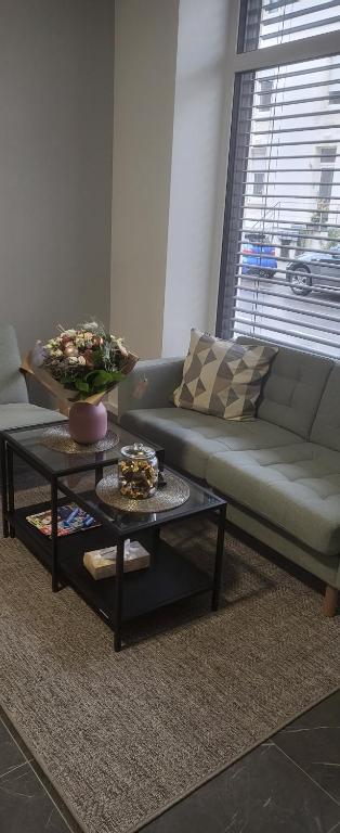 ein Wohnzimmer mit einem Sofa und einem Tisch in der Unterkunft Appartement Eco in Esch-sur-Alzette