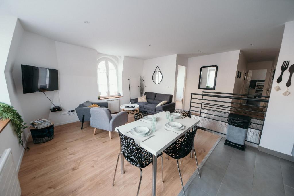 uma sala de estar com uma mesa branca e cadeiras em Appartement de Thomas em Charleville-Mézières