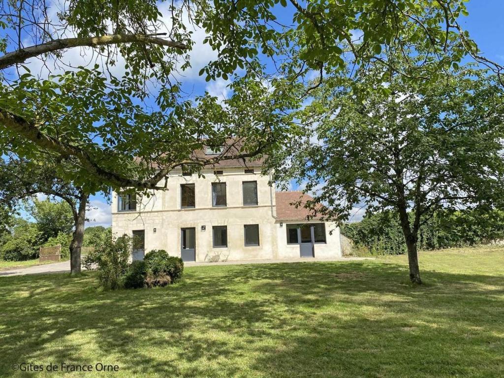a large white building in a field with trees at Gîte de Bel Oeuvre in Moulins-sur-Orne