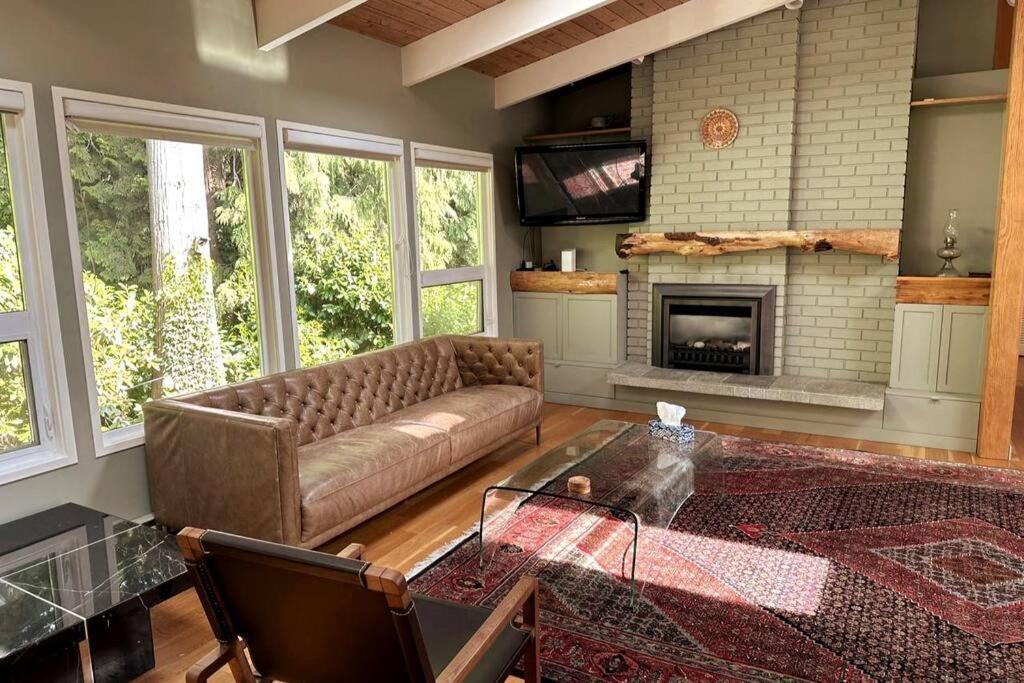 a living room with a couch and a fireplace at West Coast Contemporary Home - Central Lonsdale in North Vancouver