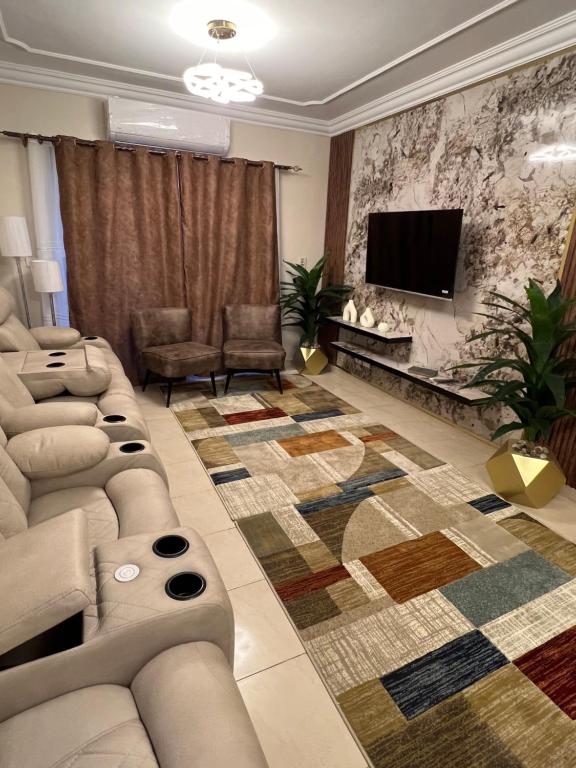 uma sala de estar com um sofá e uma televisão de ecrã plano em Luxurious VIP apartment in Madinaty furnished with high end hotel furniture em Madinaty