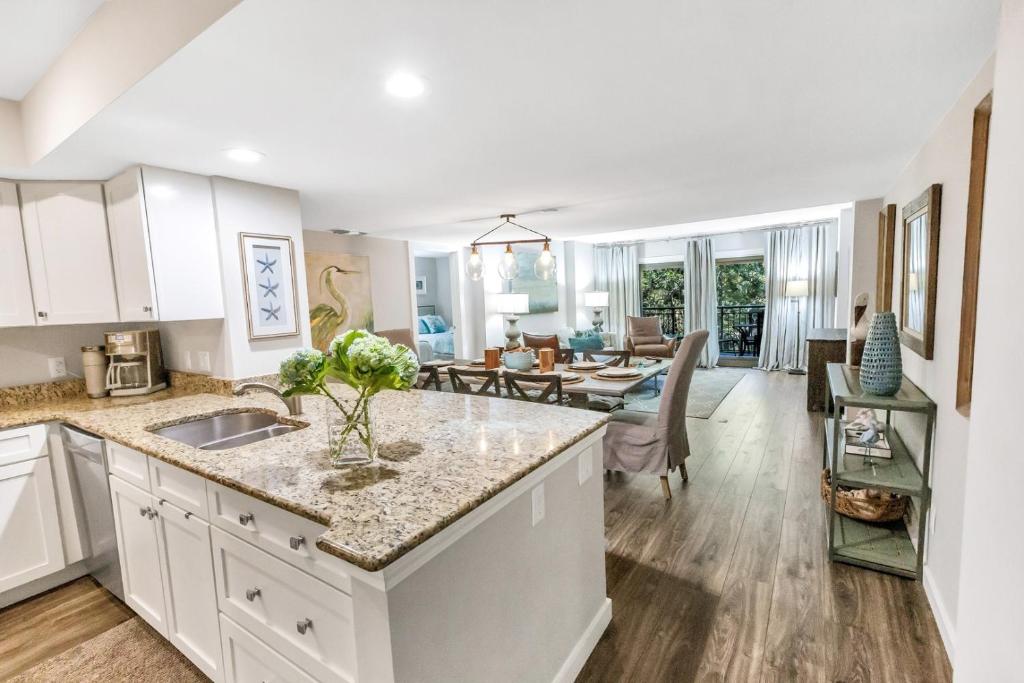 cocina y sala de estar con armarios blancos y mesa en 322 Ocean One, en Hilton Head Island