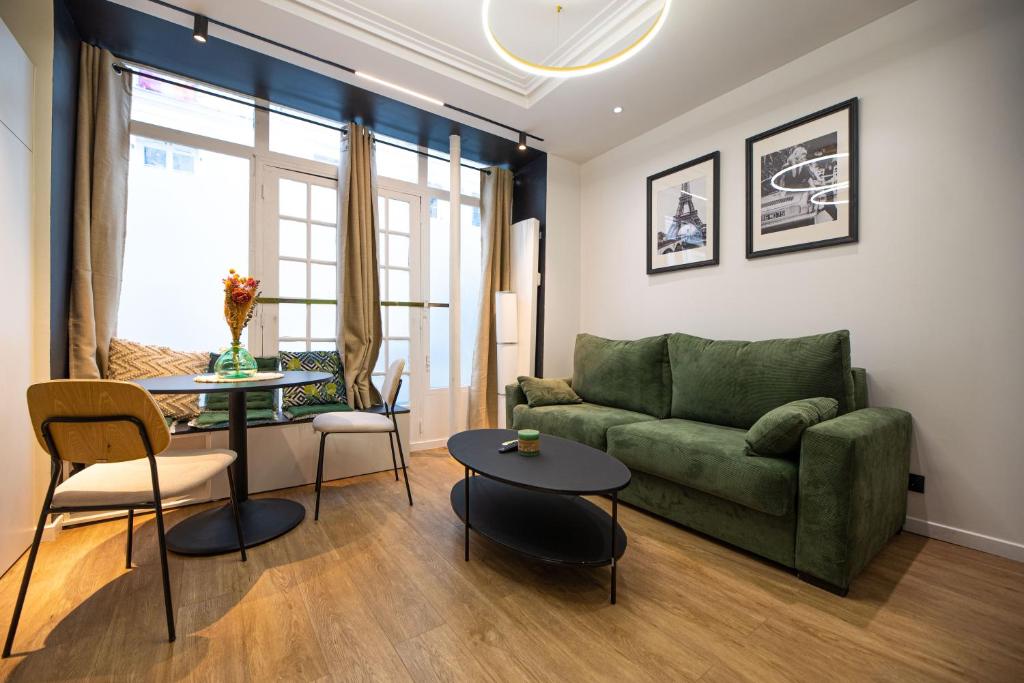 un salon avec un canapé vert et une table dans l'établissement Cosy home - Moulin rouge, à Paris