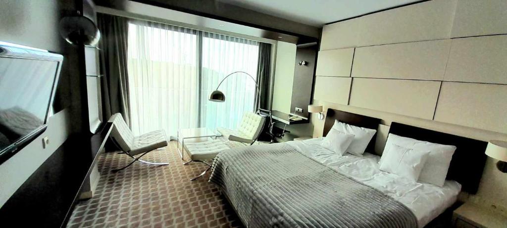 Un dormitorio con una cama y un escritorio y una ventana. en Prywatny Apartament Marine Hotel, en Kołobrzeg