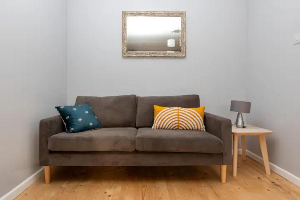 a couch in a living room with a mirror at Newly Refurbished 2BD Flat wParking - Peckham! in London