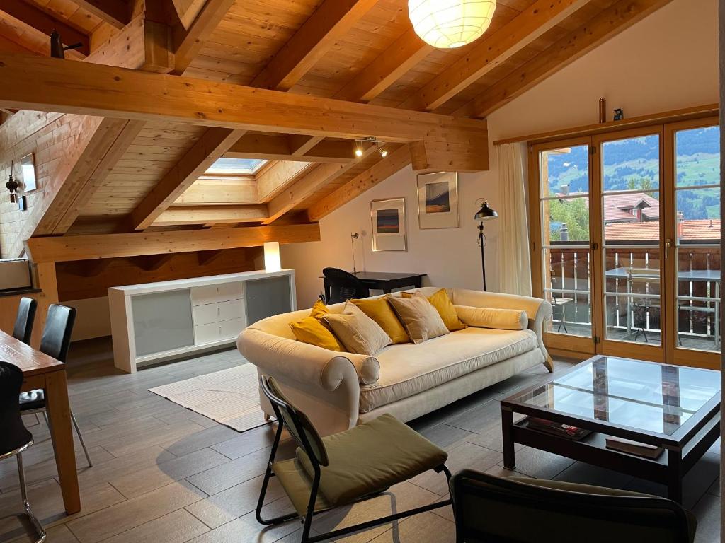 uma sala de estar com um sofá e uma mesa em Attic in the Alps em Luzein