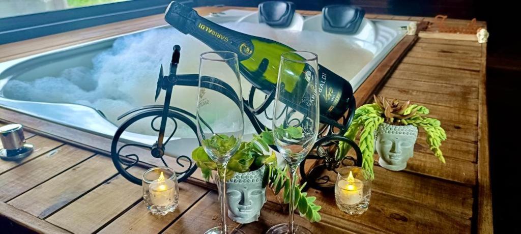 une table avec des verres et des plantes ainsi qu'une piscine dans l'établissement Chalés Cânions do Brasil, à Praia Grande