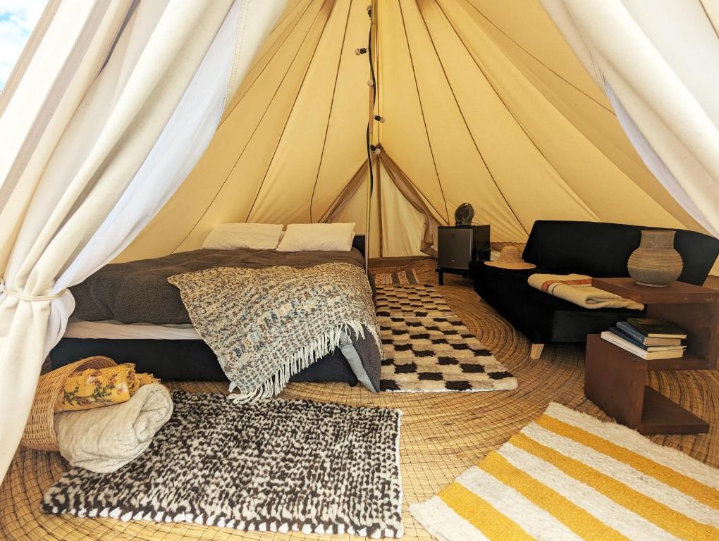 Zimmer mit einem Bett und einem Sofa in einem Zelt in der Unterkunft Glamping Yerbabuena in Toca