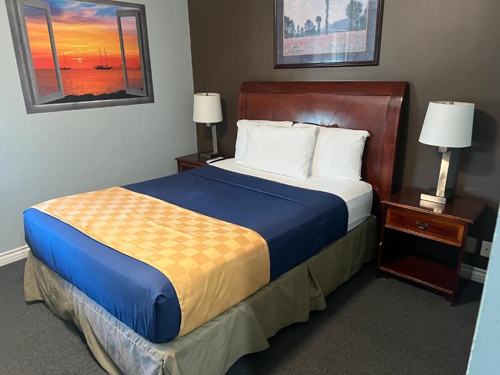 a bedroom with a large bed with a blue and yellow blanket at Knights Inn Los Angeles Central / Convention Center Area in Los Angeles