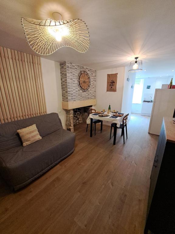 ein Wohnzimmer mit einem Sofa und einem Tisch in der Unterkunft Le Bulotier in Granville