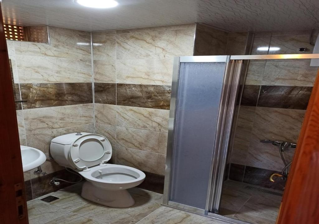 a bathroom with a toilet and a shower stall at Agon Boutique Hotel in Kemer