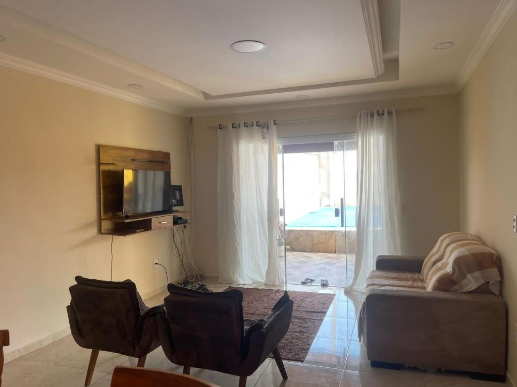 a living room with a couch and a tv at Casa de buzios in Búzios