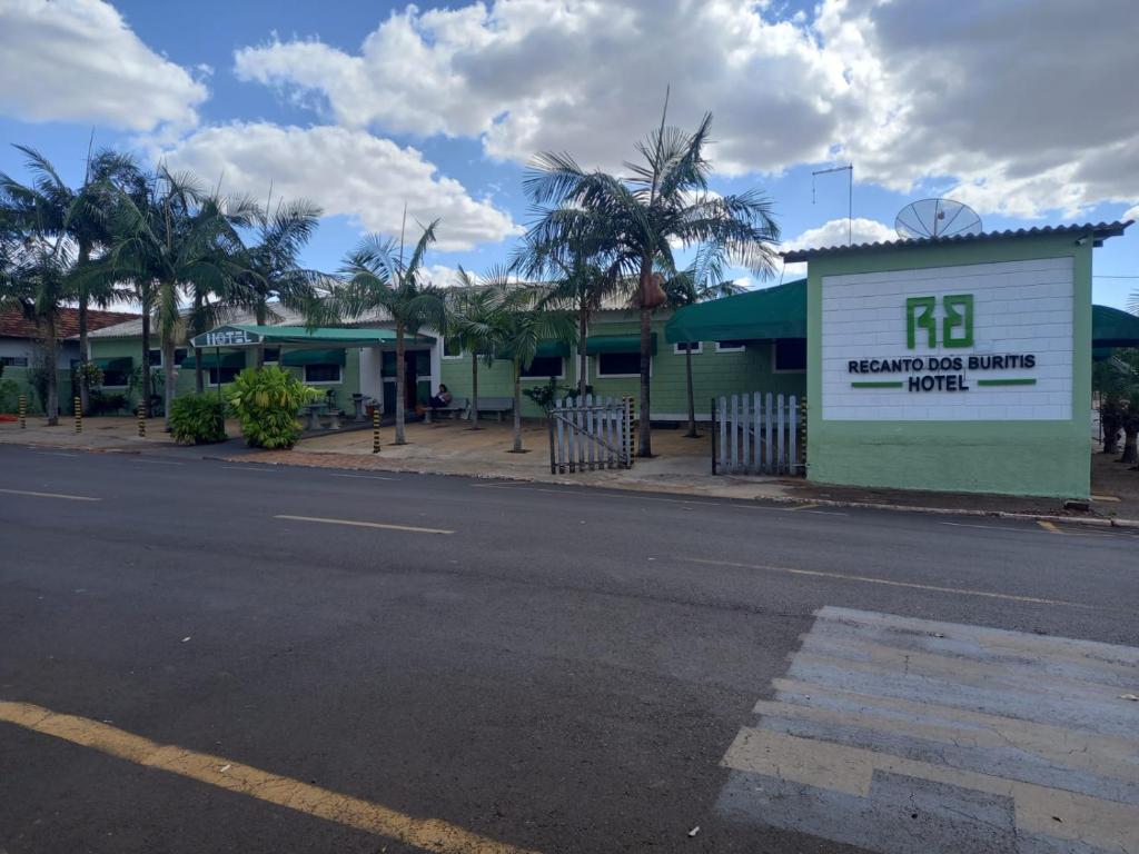a building with a sign on the side of a street at HOTEL RECANTO DOS BURITIS in Buritizal