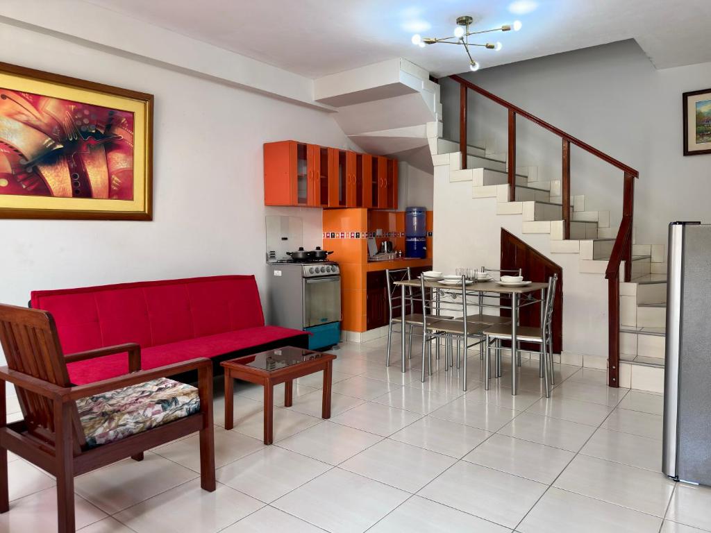 ein Wohnzimmer mit einem roten Sofa und einer Küche in der Unterkunft La Condamine Apart Hotel in Iquitos