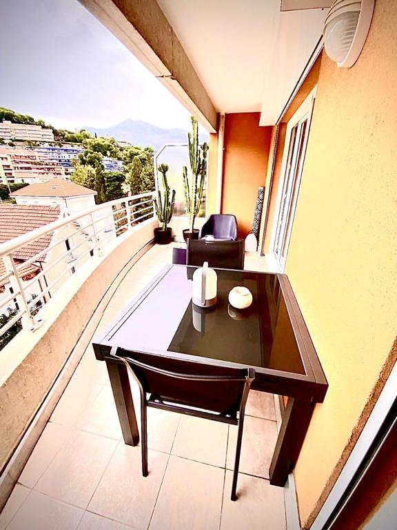 - un balcon avec une table et un canapé dans un bâtiment dans l'établissement L’Exotique, à Menton