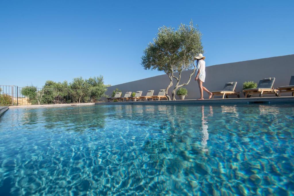 a person standing next to a swimming pool at Villa Madra in Bonifacio