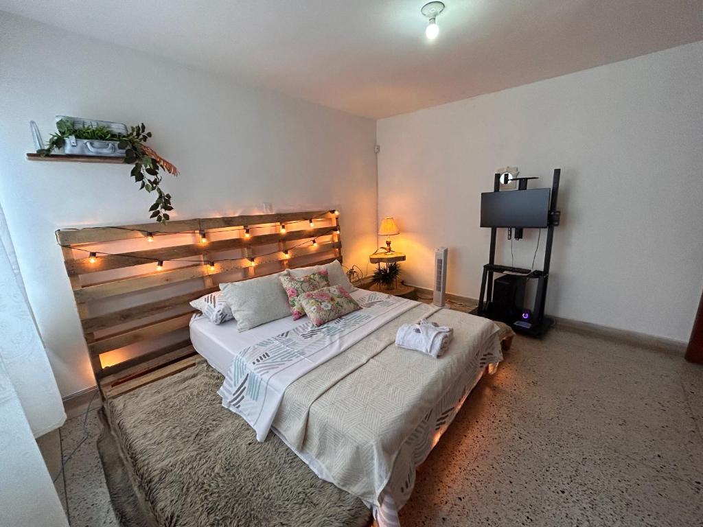 - une chambre avec un grand lit éclairé dans l'établissement Casa Purple Hostel, à Medellín