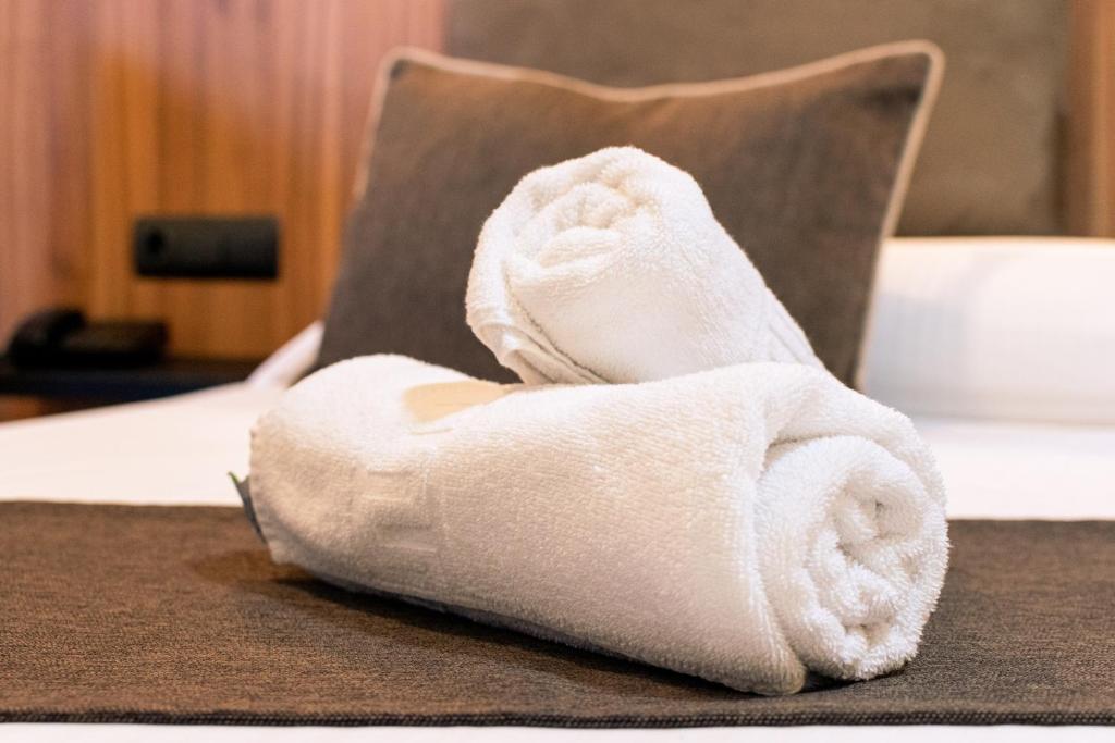 a white towel sitting on top of a bed at Gce Hoteles in Cártama