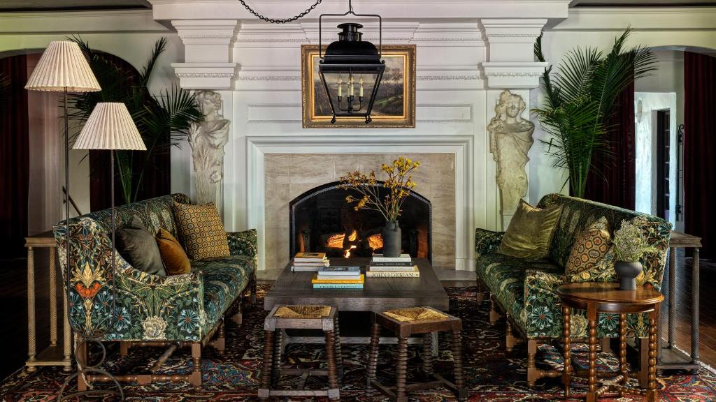 a living room with two couches and a fireplace at La Playa Hotel in Carmel