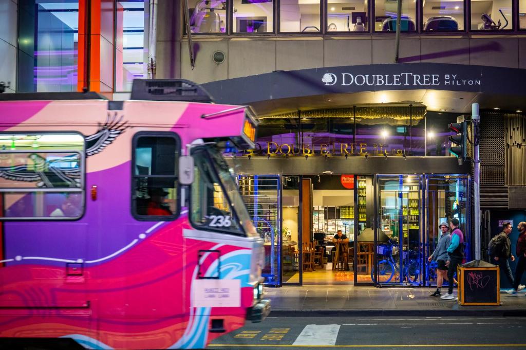 un autobús rosa estacionado frente a un restaurante en DoubleTree by Hilton Melbourne, en Melbourne