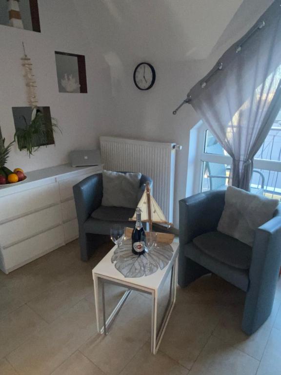 a living room with two chairs and a table at Apartament Bella in Międzyzdroje