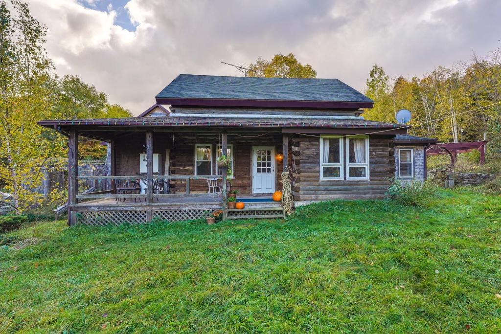 uma pequena casa com um alpendre num campo de relva em Cozy Cabin in West Chazy with Lake Champlain View! 