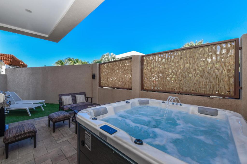 een hot tub op een patio met een hek bij Aracari 1 in Palm-Eagle Beach