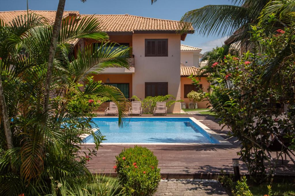 uma piscina em frente a uma casa em A 450m da PRAIA de TAPERAPUAN, no 2 pavimento, Piscina, Churrasqueira, 2 quartos, até 6 pessoas, WiFi independente 300 mbs, Estacionamento Gratuito, Próximo a mercado e restaurantes em Porto Seguro