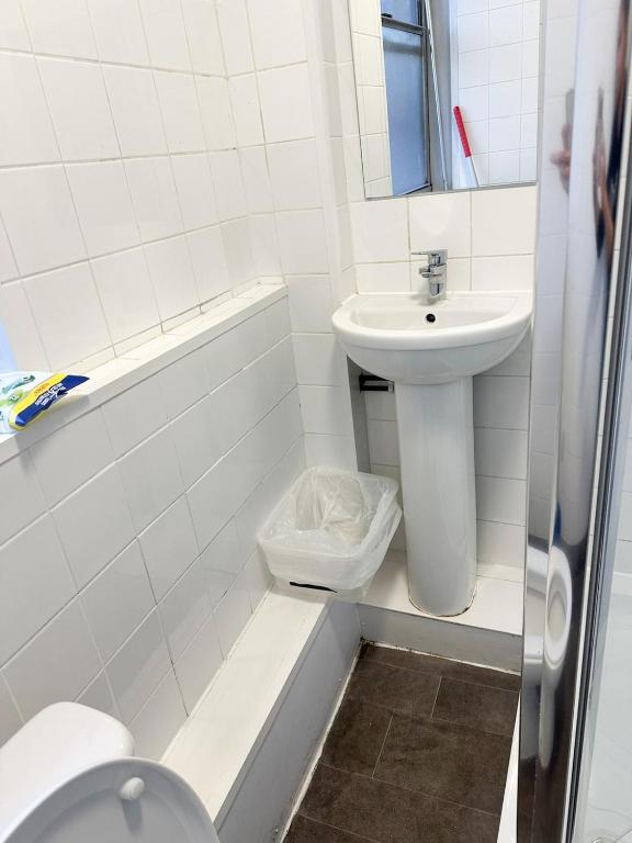 a white bathroom with a toilet and a sink at 264 rooms in London