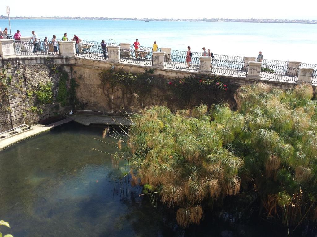 people walking on a bridge over a body of water at Casa Orchidea in Siracusa