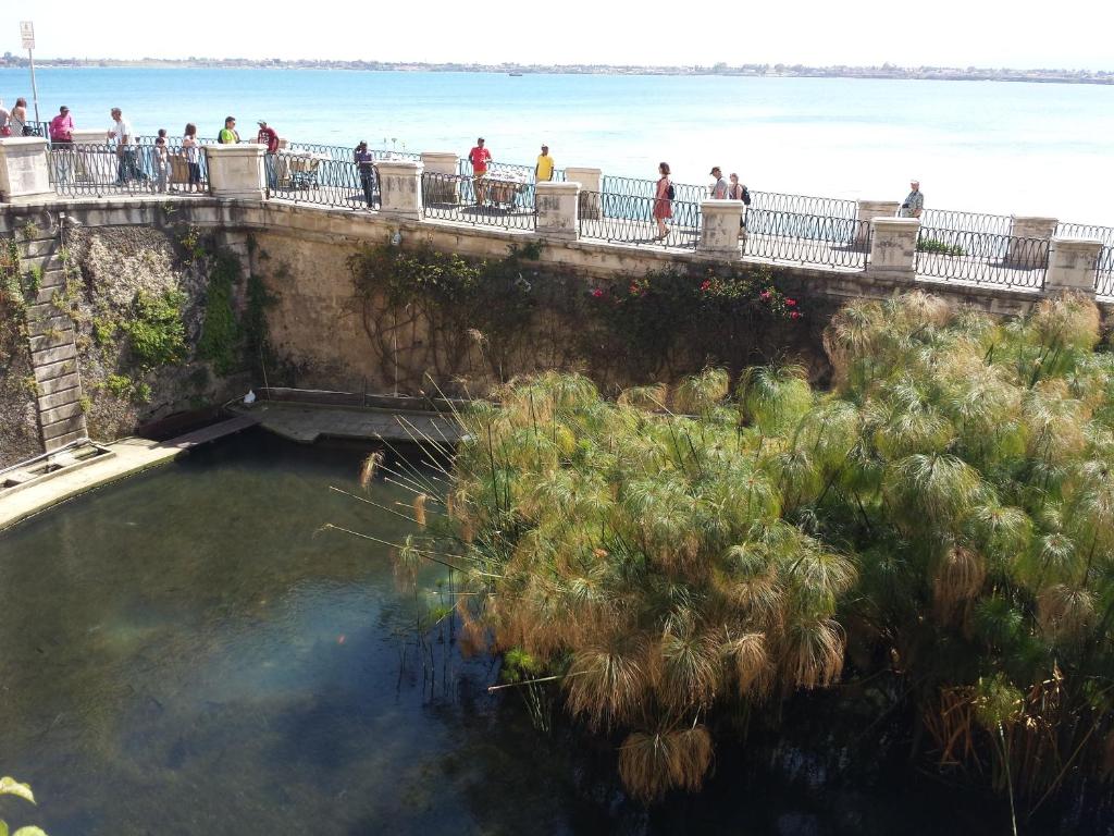 people walking on a bridge over a body of water at Casa Orchidea in Syracuse