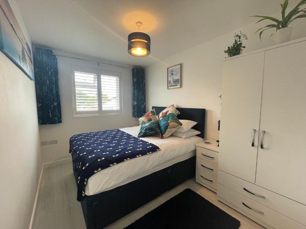 a small bedroom with a bed and a cabinet at The Blue Crab in Bournemouth in Bournemouth
