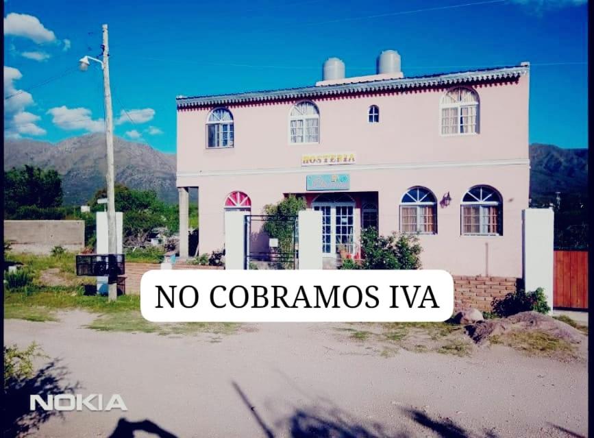 un bâtiment blanc avec un panneau indiquant pas de corona virus ivva dans l'établissement Hosteria Dharma, à Capilla del Monte