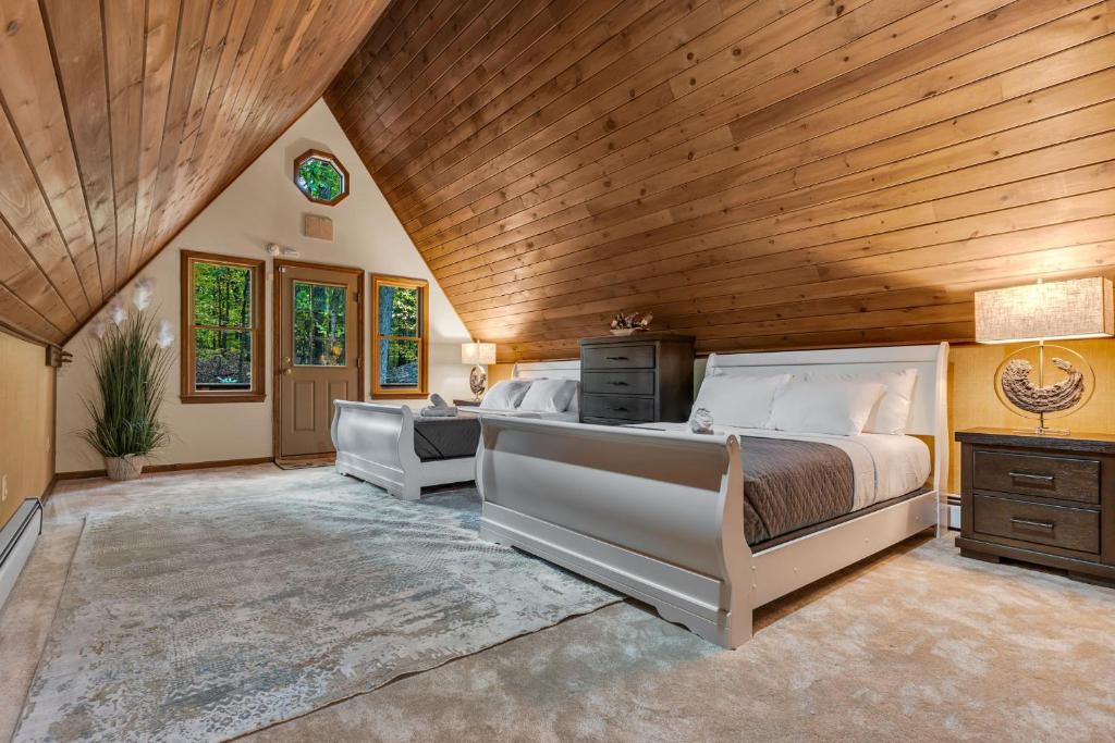 a bedroom with a large bed and a wooden ceiling at Star Gazer Luxury A-Frame Wood Cabin. Near York/Harrisburg/Hershey/Lancaster in Goldsboro