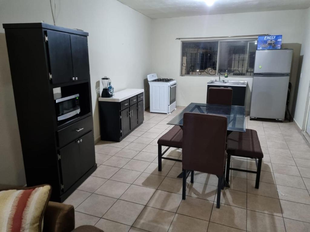 a kitchen with a table and chairs and a refrigerator at Departamento Victoria in Saltillo