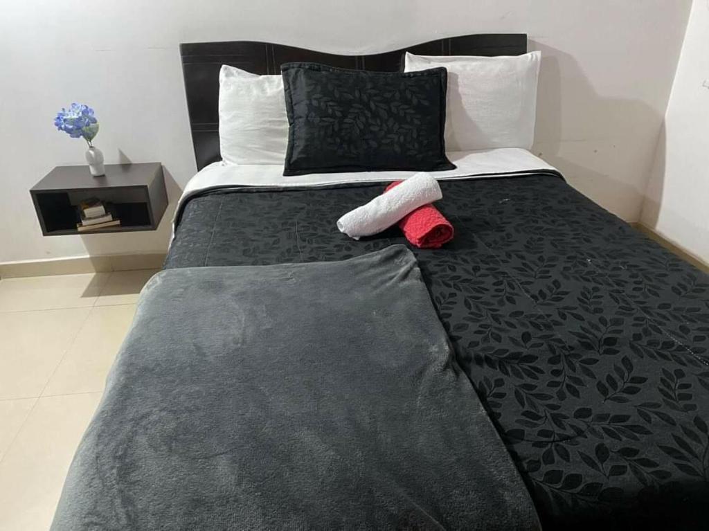 1 cama grande con edredón negro y 2 almohadas en APARTAESTUDIOS BOGOTÁ, en Bogotá