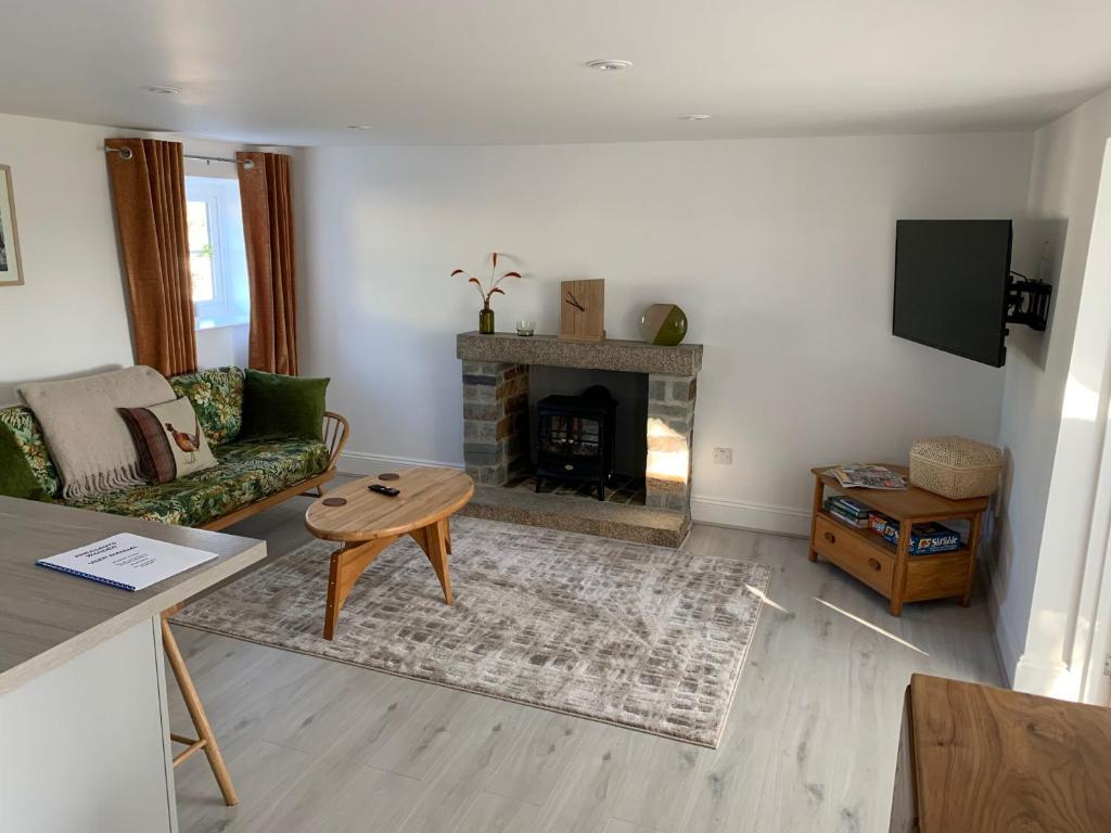 a living room with a couch and a fireplace at Pheasants Wander in Newquay