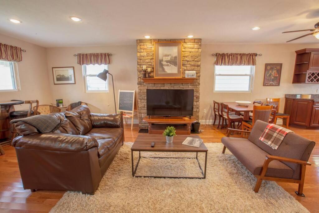 a living room with a leather couch and a television at Stunning City Living Open Floor Plan in Pittsburgh