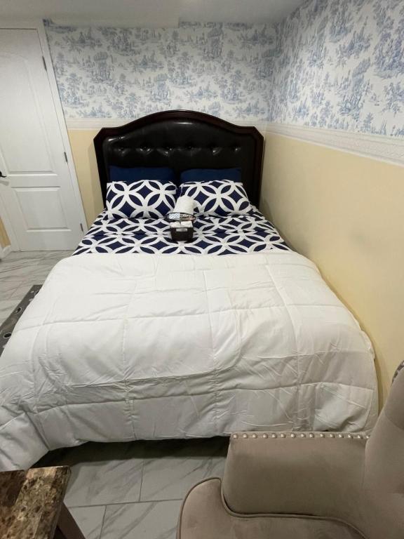a bedroom with a large bed with blue and white sheets at A cool unique place from home in Elmont