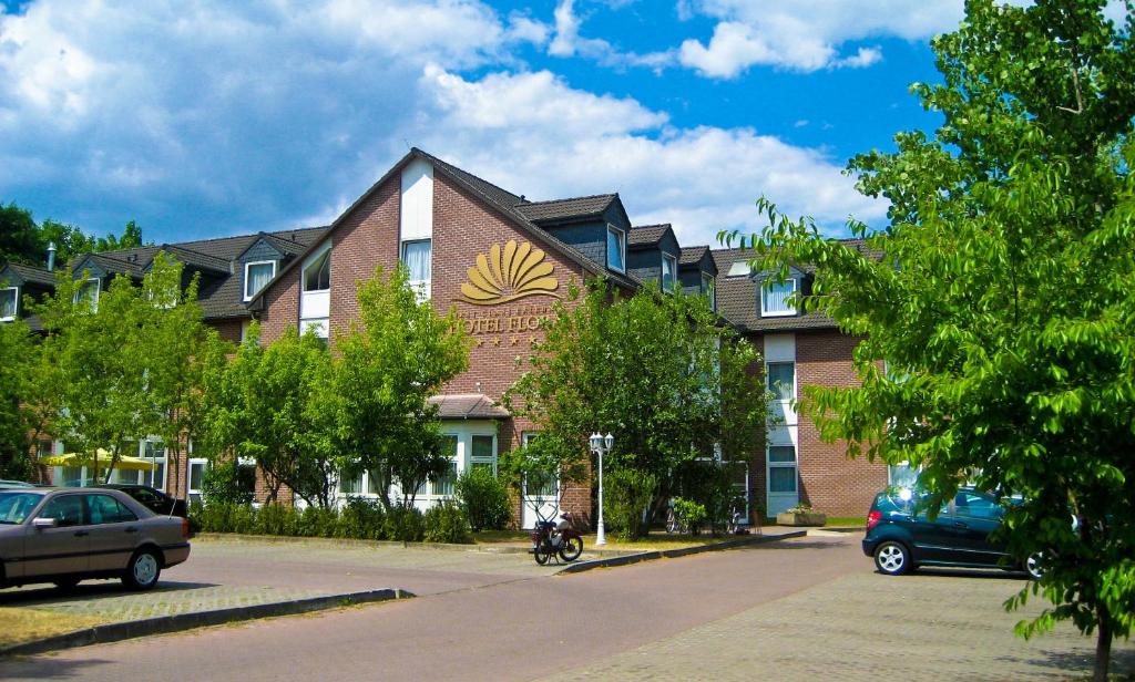 un edificio con una motocicleta estacionada frente a él en Hotel Flora, en Fredersdorf