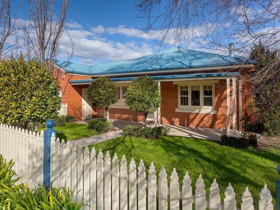 a brick house with a white picket fence at 'Ampleforth East' in Albury