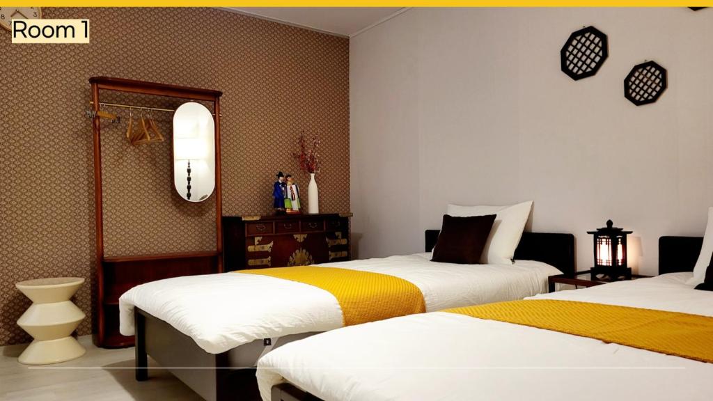 a bedroom with two beds with white and yellow at underhill in Incheon