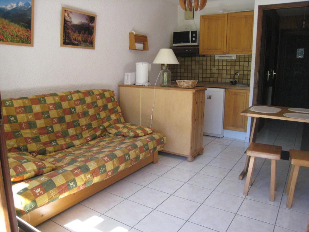 a living room with a couch and a kitchen at Studio La Clusaz, 1 pièce, 4 personnes - FR-1-459-120 in La Clusaz